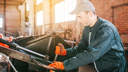 Auszubildender beim Warten einer landwirtschaftlichen Maschine