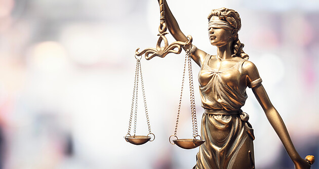 Statue Justitia Das Foto zeigt eine Statue aus Bronce mit verbundenen Augen und einer Waage in den Händen