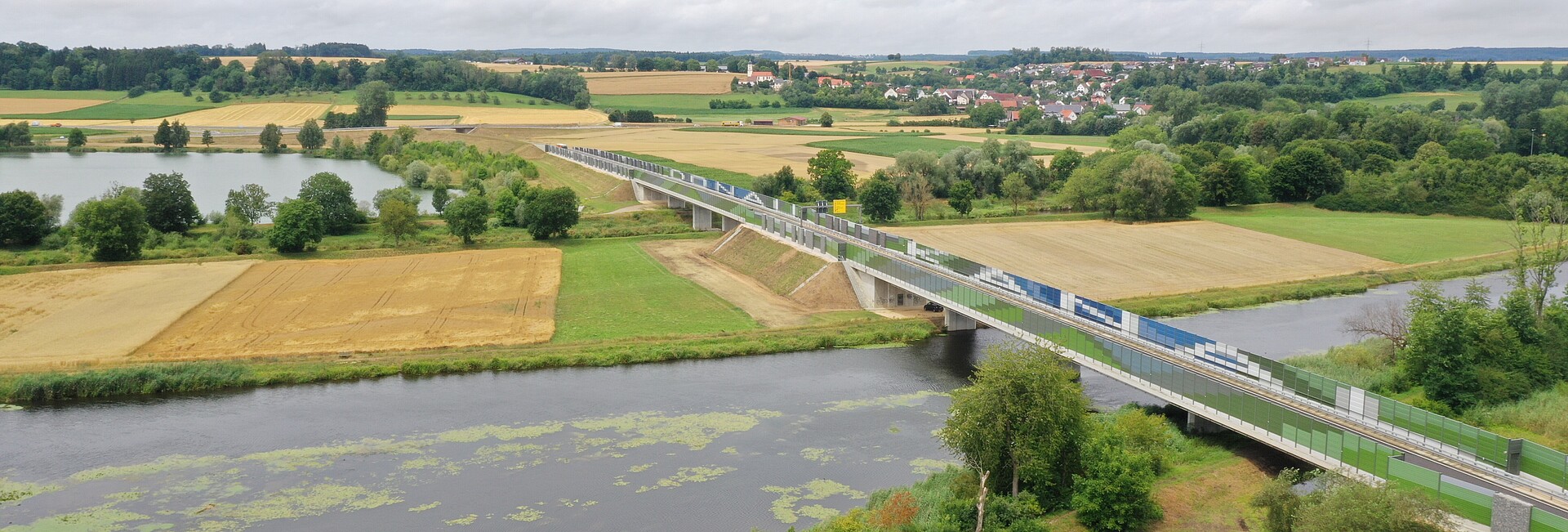 Luftbild von zwei Brücken über Gewässer. Auf den Irritationsschutzwänden stehen die Wörter "Donau" und "Kanal"Luftbild von zwei Brücken über Gewässer. Auf den Irritationsschutzwänden stehen die Wörter "Donau" und "Kanal"