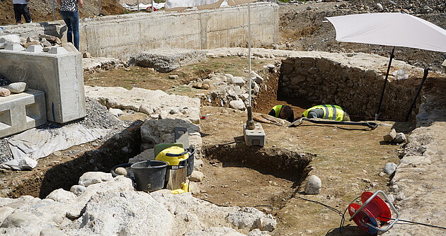 In der Bildmitte ist die Apsis der zweiten Bauphase zu sehen, die sich links hinter dem Betonstein fortsetzt. Im Hintergrund ist die Apsis der 1957 abgerissenen Kirche erkennbar.