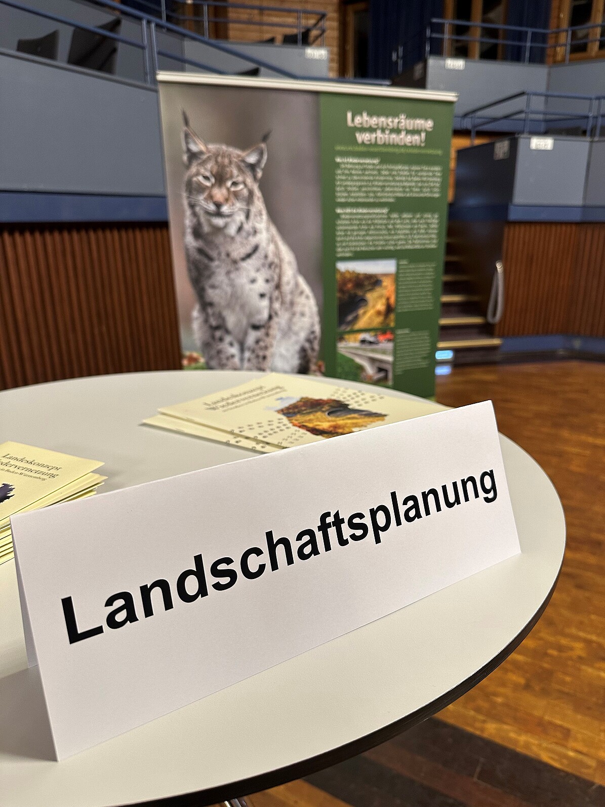 Tisch mit Aufsteller Landschaftsplanung, dahinter steht ein Buch