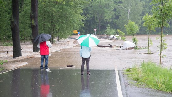 Passanten betrachten die überflutete Straße