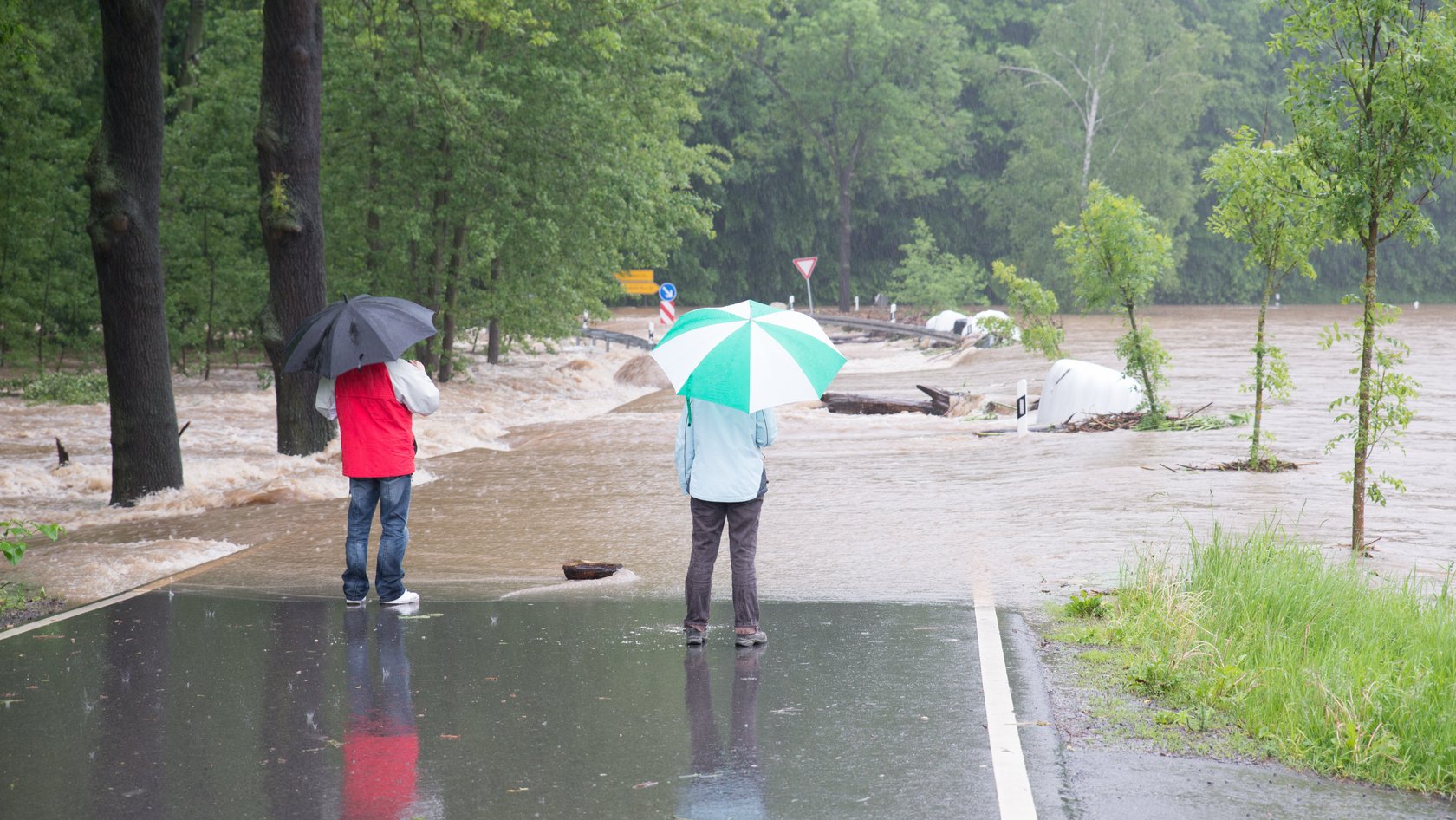 Passanten betrachten die überflutete Straße