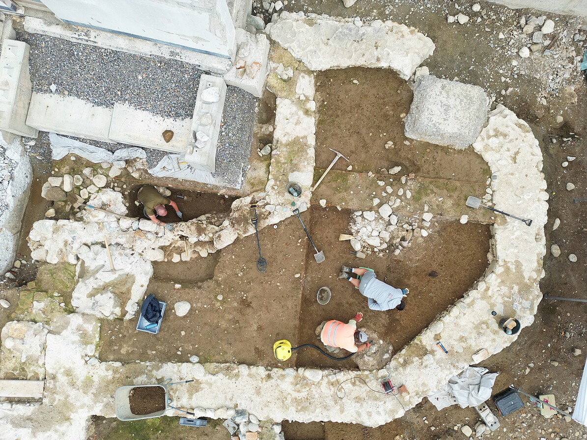 Blick von oben auf die Mauerreste der drei erfassten Bauphasen. Oben links der statisch abgesicherte historische Kirchturm.