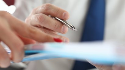 Mann und Frau halten einen Ordner mit Dokumenten