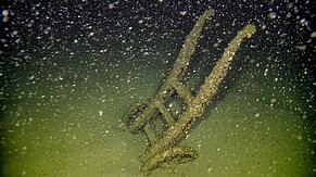 Eine von einem Wrack gestürzte hölzerne Sackkarre am Seegrund des Boden