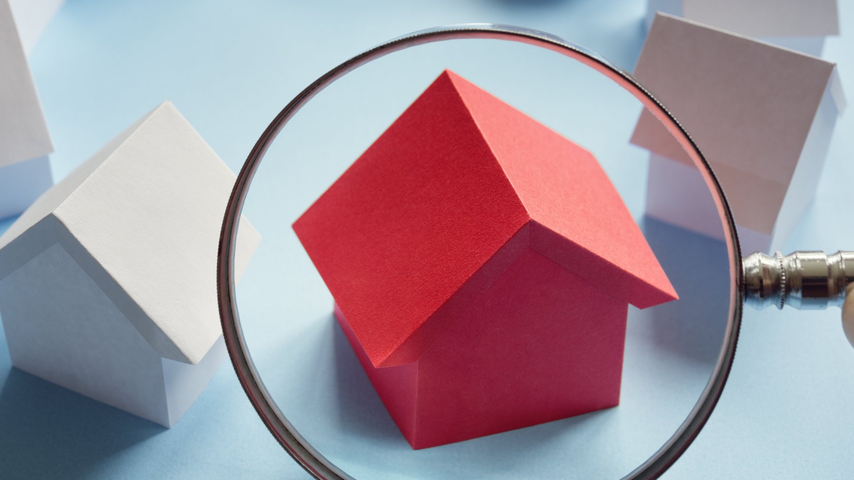 es stehen 8 Häuschen im Kreis, 7 davon sind weiß, eines ist rot. Dieses wird durch eine Lupe betrachtet