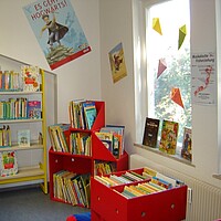 Kinderecke mit roten Bilderbuchtrögen in der Stadtbücherei Albstadt - Zweigstelle Onstmettingen