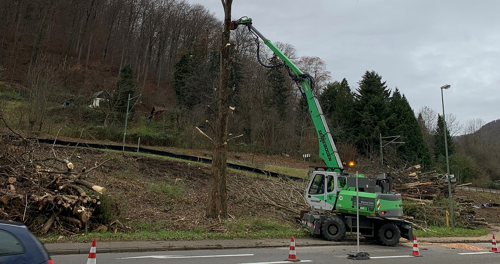 Das Foto zeigt ein Maschine bei Baufällarbeiten neben einer Straße