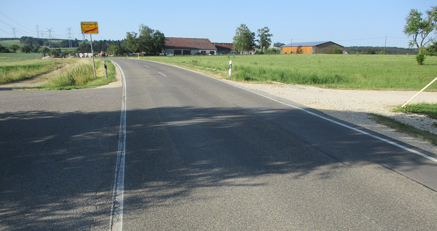 Das Foto zeigt die L 249 in Richtung Oberwilzinge; links und rechts Wiesen; im Hintergrund eine Ortschaft