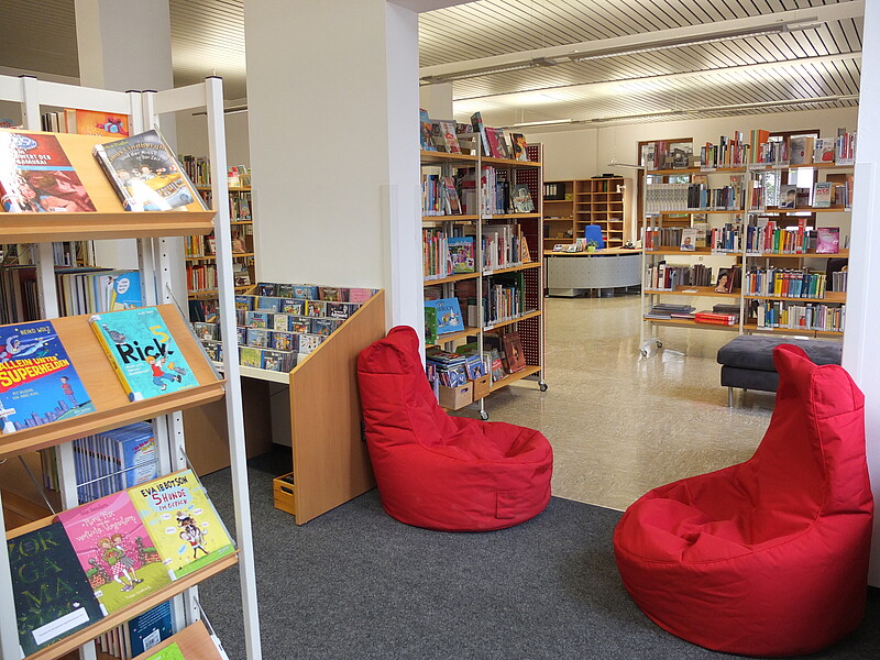 Kinderbuchbereich mit roten Sitzsäcken in der Gemeindebücherei Kirchentellinsfurt