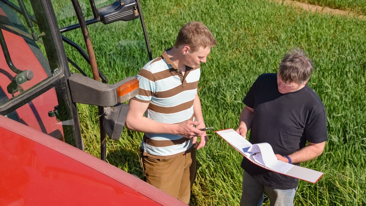 Landwirt und Mitarbeiter besprechen sich auf dem Feld