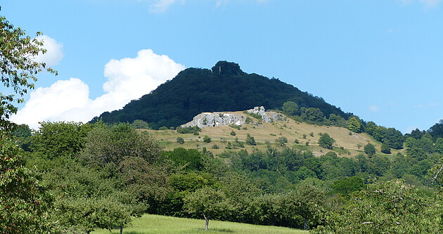 Blick zum Naturschutzgebiet Spielburg (im Mittelgrund) mit Felsen und Kalk-Magerrasen, dahinter der Hohenstaufen