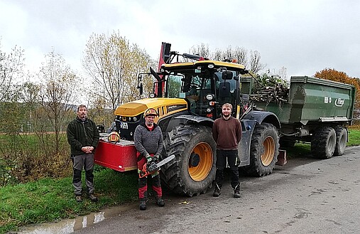 Bild zeigt Traktor und Mitarbeiter