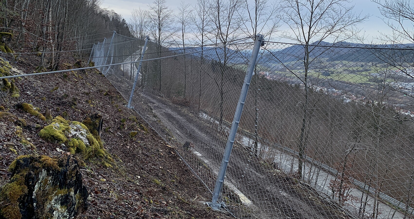 Das Foto zeigt einen Hang, der mit einem Zaun gesichert ist