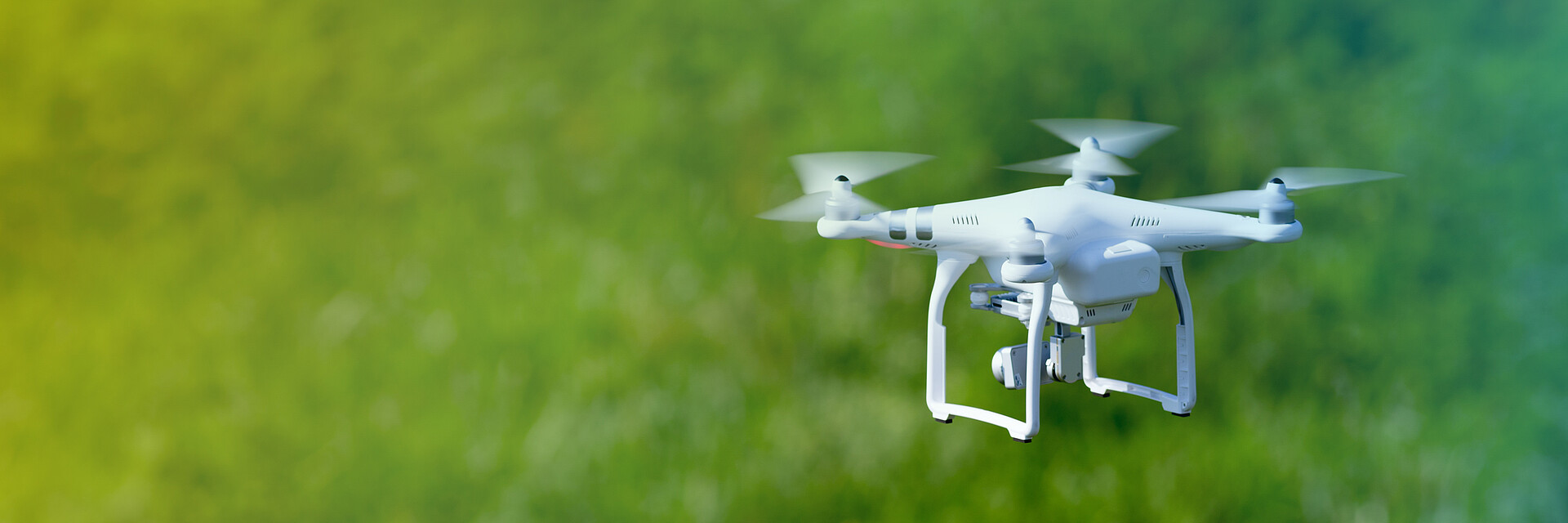 Quadcopter Drohne fliegt über ein Feld