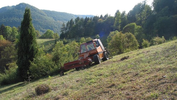 Ein Mähfahrzeug fäht über eine Wacholderheide auf der Schwäbischen Alb