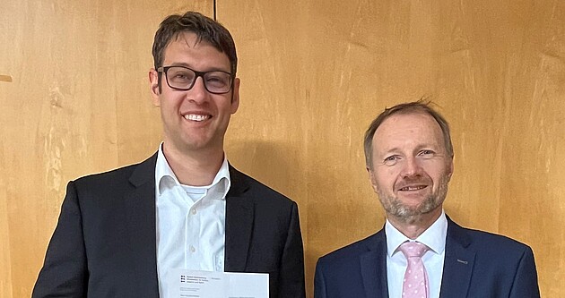 Dr. Thomas Hölz (rechts), Leiter des Gymnasialreferats am Regierungspräsidium Stuttgart, überreicht Benjamin Brack (links) das Bestellungsschreiben von Kultusministerin Theresa Schopper. Quelle: Friedrich-Schiller-Gymnasium Fellbach Dr. Thomas Hölz (rechts), Leiter des Gymnasialreferats am Regierungspräsidium Stuttgart, überreicht Benjamin Brack (links) das Bestellungsschreiben von Kultusministerin Theresa Schopper. Quelle: Friedrich-Schiller-Gymnasium Fellbach