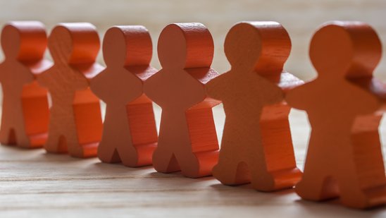 Auf dem Bild ist eine Menschenkette aus Figuren zu sehen.