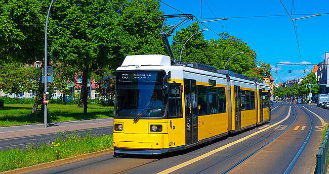 Straßenbahn - Öffentlicher Nahverkehr im Sommer mit grünen Bäumen