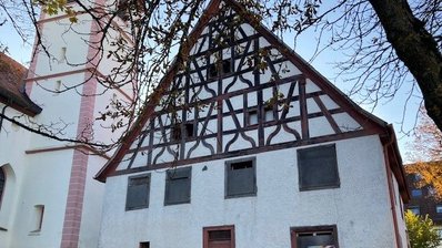 Vorderansicht des Hauses mit Kirche daneben