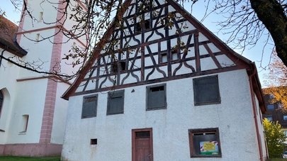 Vorderansicht des Hauses mit Kirche daneben