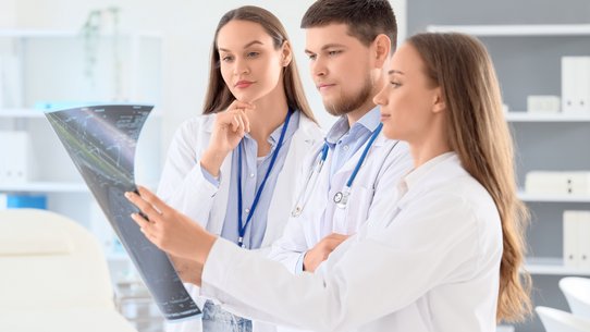 Bild zeigt Studierende, die eine Röntgenaufnahme untersuchen