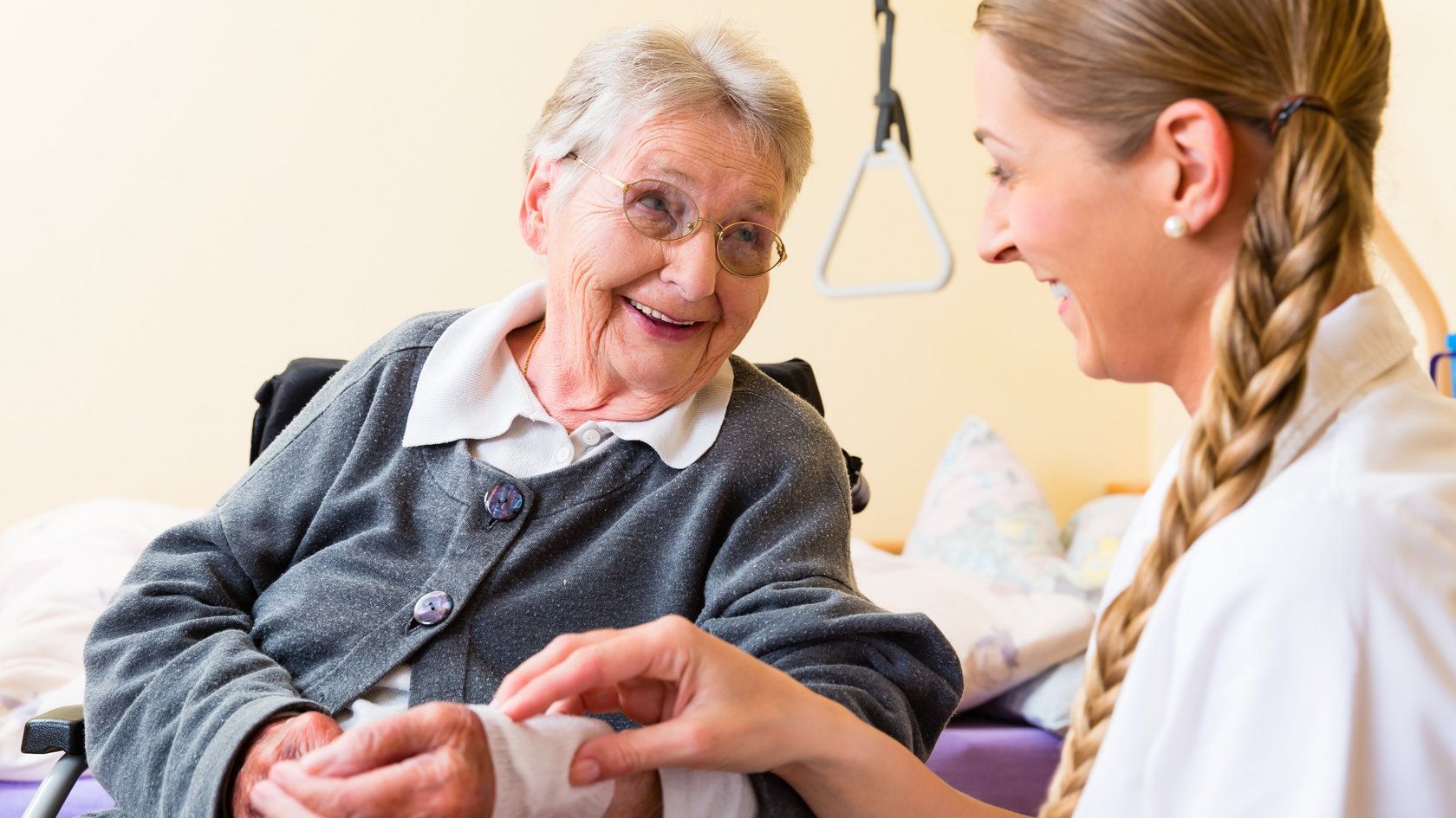 Pflegerin kümmert sich um Seniorin im Altenheim