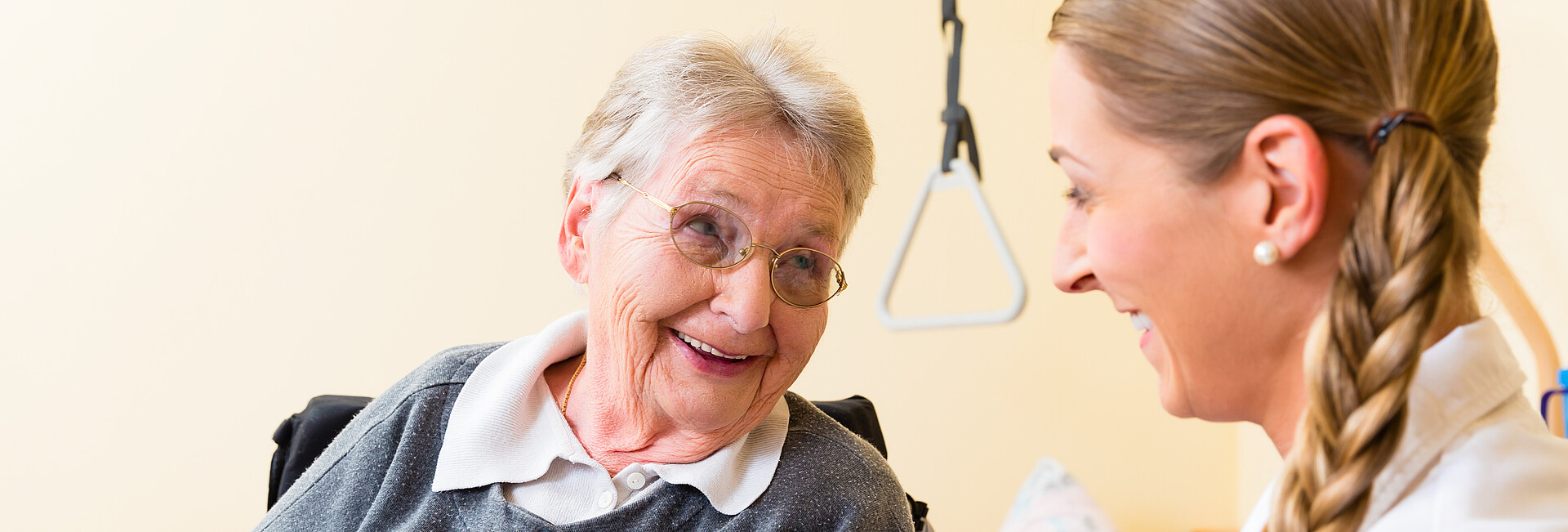 Pflegerin kümmert sich um Seniorin im Altenheim