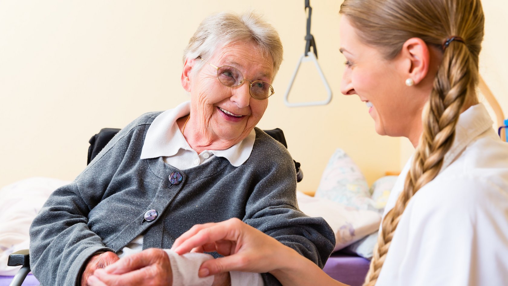 Pflegerin kümmert sich um Seniorin im Altenheim