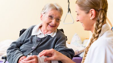 Pflegerin kümmert sich um Seniorin im Altenheim