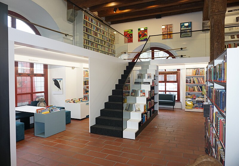 Erdgeschoss der Stadtbücherei Wangen im Allgäu mit Blick auf Treppenaufgang zur Galerie