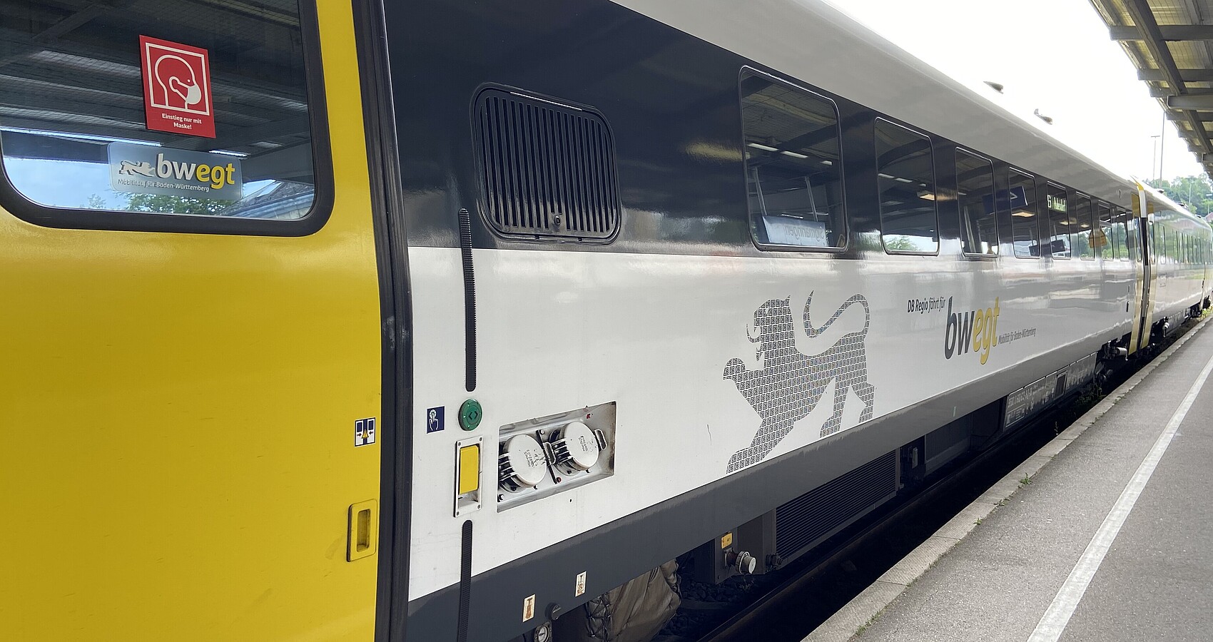 Gelb-schwarzer Wagon des Nahverkehrs steht in einem Bahnhof