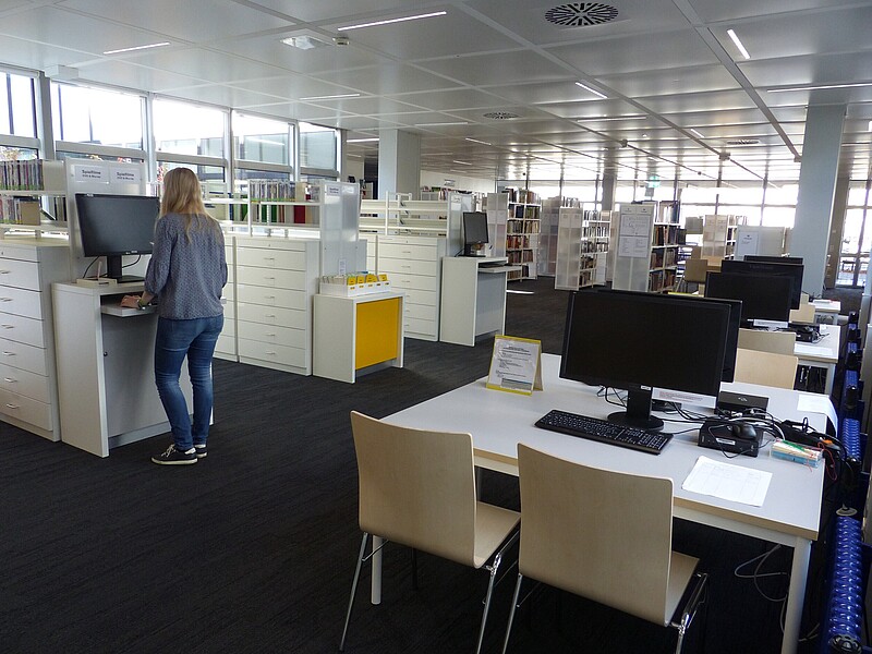 Überblick über den Bibliotheksraum in der Bibliothek/Mediothek im Kreisberufschulzentrum Biberach mit OPAC, Arbeitsplätzen und Regalen