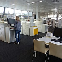 Überblick über den Bibliotheksraum in der Bibliothek/Mediothek im Kreisberufschulzentrum Biberach mit OPAC, Arbeitsplätzen und Regalen