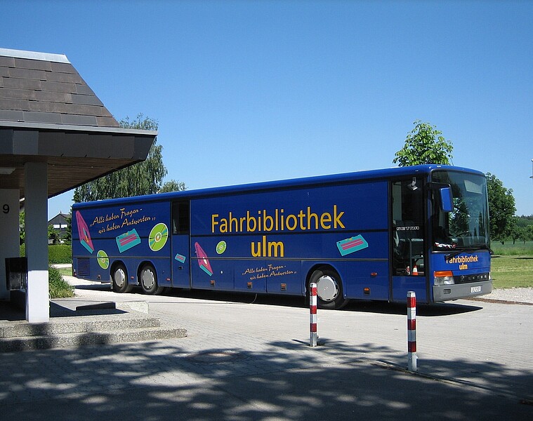 Dunkelblauer Fahrbibliotheksbus der Stadtbibliothek Ulm mit gelben Schriftzug "Fahrbibliothek Ulm"