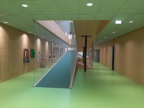 Neubau Kindergarten Markdorf Süd - Blick in das Innere, man sieht einen Treppenaufgang mit grünem Linoleum