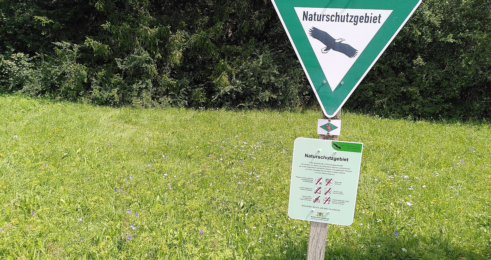 Auf diesem Bild sehen Sie die Beschilderung mit dem Dreiecksschild als Erkennungszeichen der Naturschutzgebiete wird durch neue Infotafeln ergänzt.