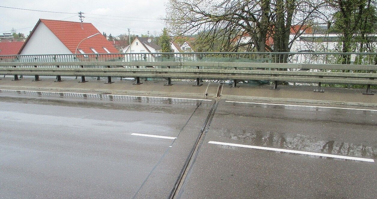 Das Bild zeigt die Übergangskonstruktion der Lochenbachbrücke bei Balingen-Weilstetten in Fahrtrichtung Albstadt; im Hintergrund sieht man das Brückengeländer und mehrere Häuser