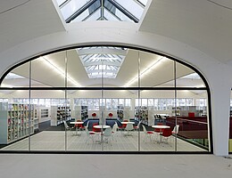Blick durch die Scheibe auf das Lesecafé in der Stadtbücherei Mössingen in der Tonnenhalle im Pausa-Quartier