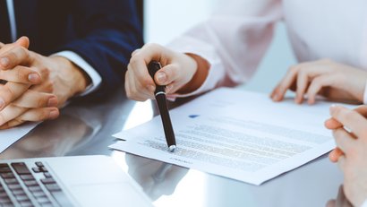 Mehrere Personen sitzen an einem Tisch und diskutieren 