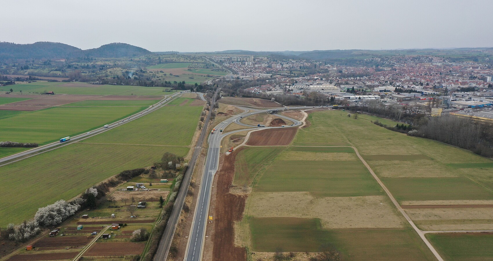 Luftbild der B 28 neu zwischen Tübingen Rottenburg; man sieht die B 28 und angrenzende Äcker, Wiesen und Felder und im Hintergrund Rottenburg