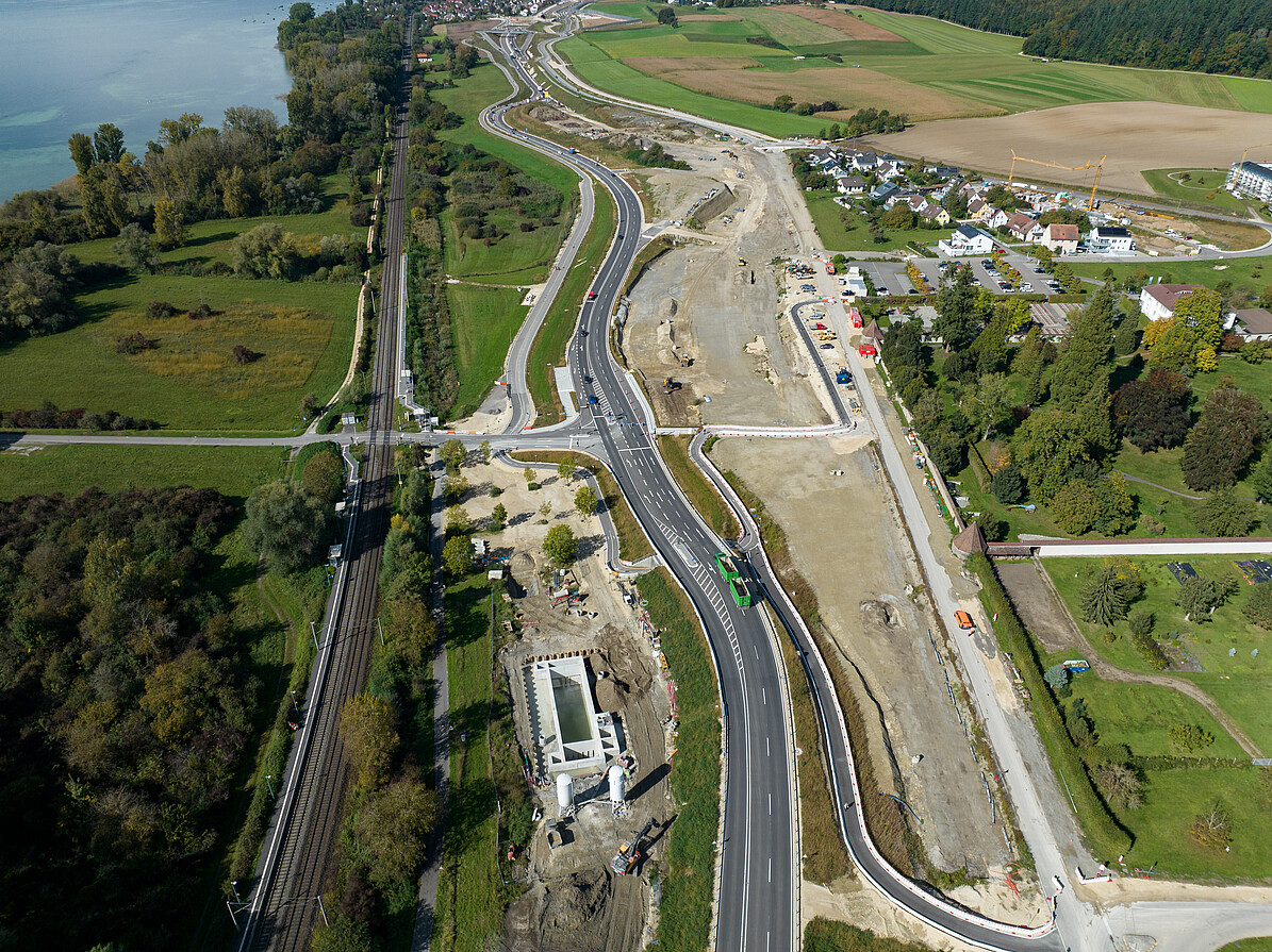 Luftbild der gesamten Baustelle: Um überschüssiges Wasser aus dem Boden zu pressen, wird bei der „Vorkonsolidierung“ die auf dieser Ansicht nicht bewachsene Fläche in der Bildmitte mit Erdmassen belastet