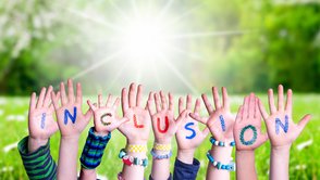 In die Höhe gestreckt Kinderhände mit den Buchstaben von Inclusion