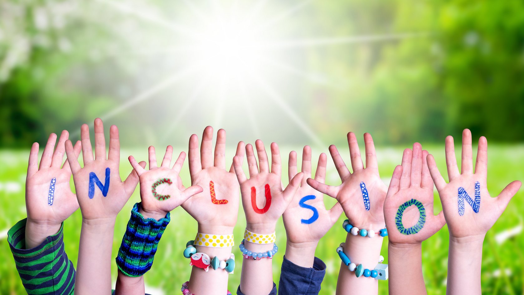 In die Höhe gestreckt Kinderhände mit den Buchstaben von Inclusion