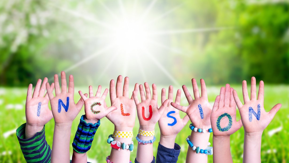 In die Höhe gestreckt Kinderhände mit den Buchstaben von Inclusion