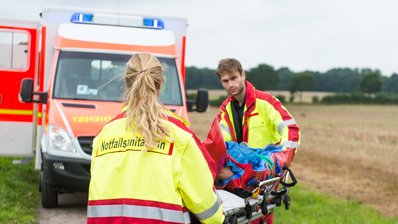 Junge Frau wird von der Rettungswagenbesatzung versorgt und in den Rettungswagen gebracht