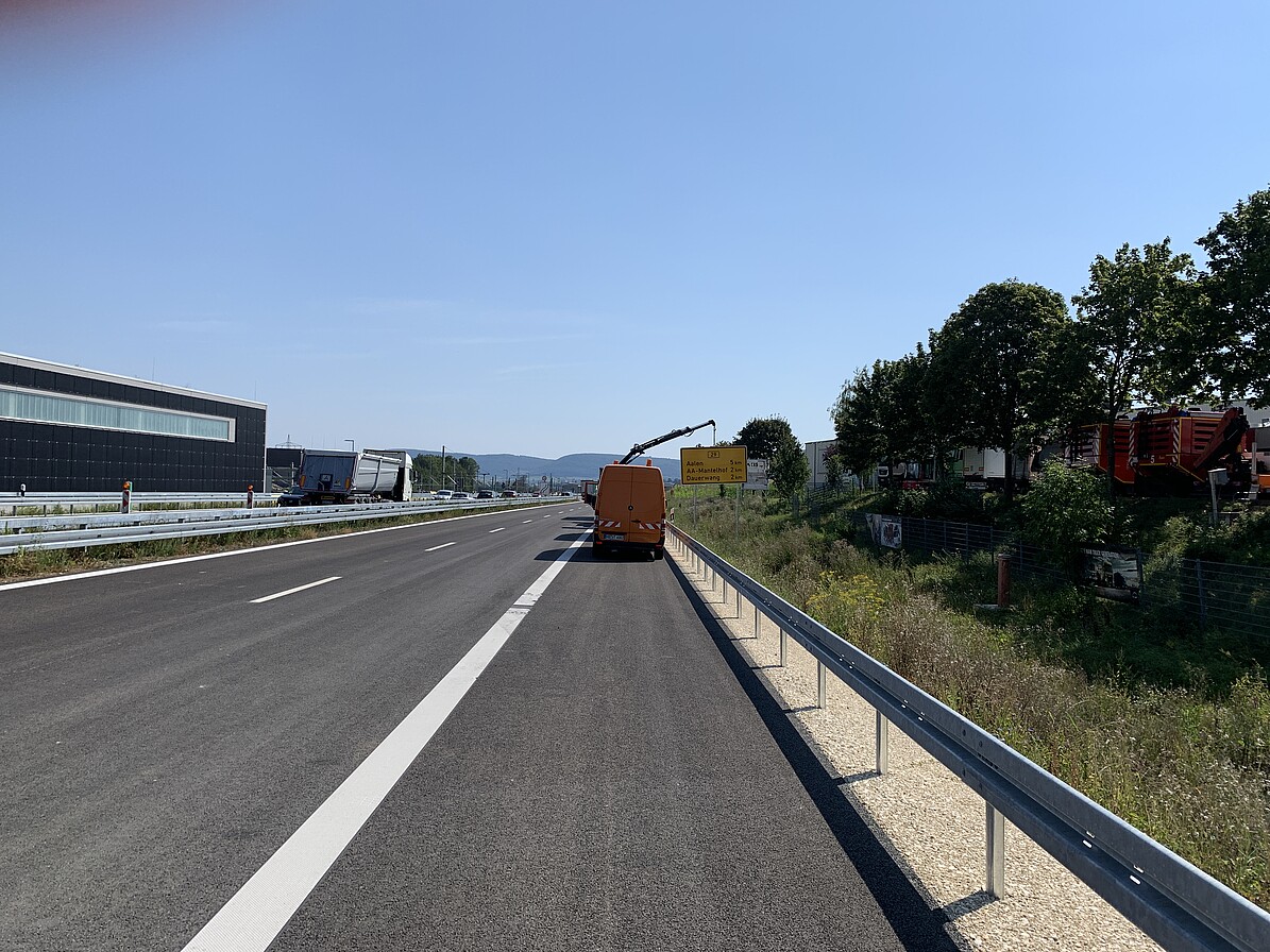 Straße mit Seitenstreifen, darauf ein Fahrzeug