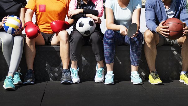 Sportler aus verschieden Sportarten sitzen beieinander