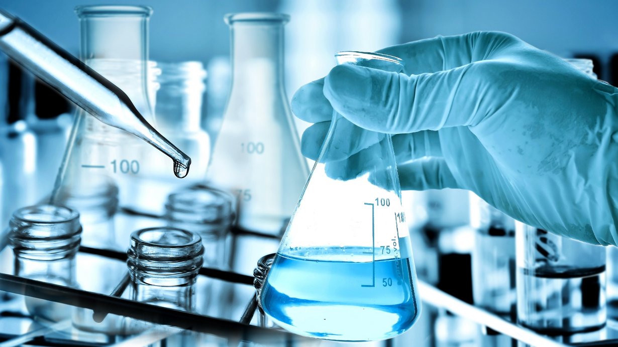 Bild zeigt Laborflasche, in die Flüssigkeit geträufelt wird